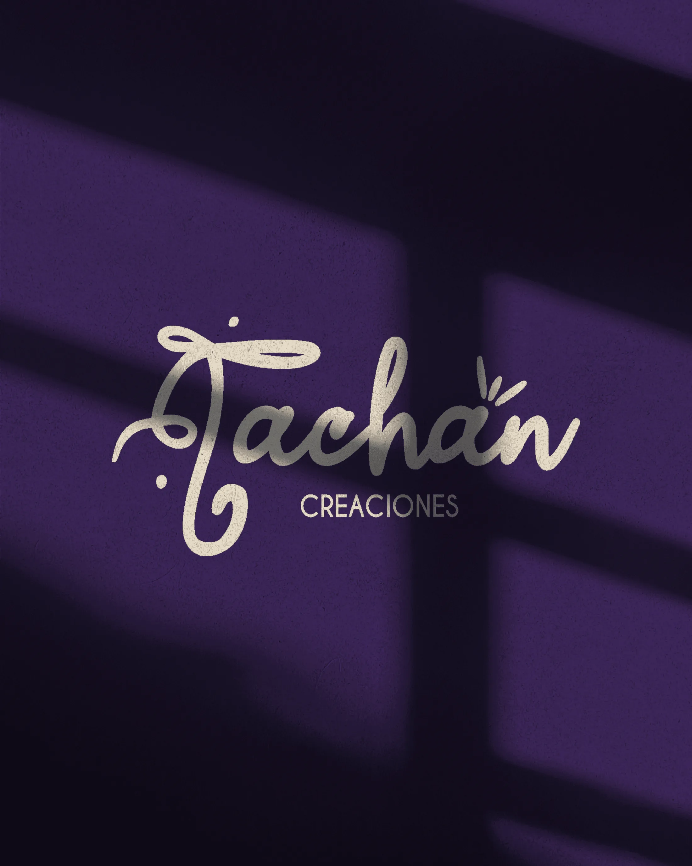Logotipo manuscrito de Tachán Creaciones sobre papel texturado
